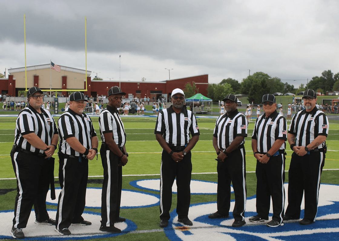 Football referees standing on the field.