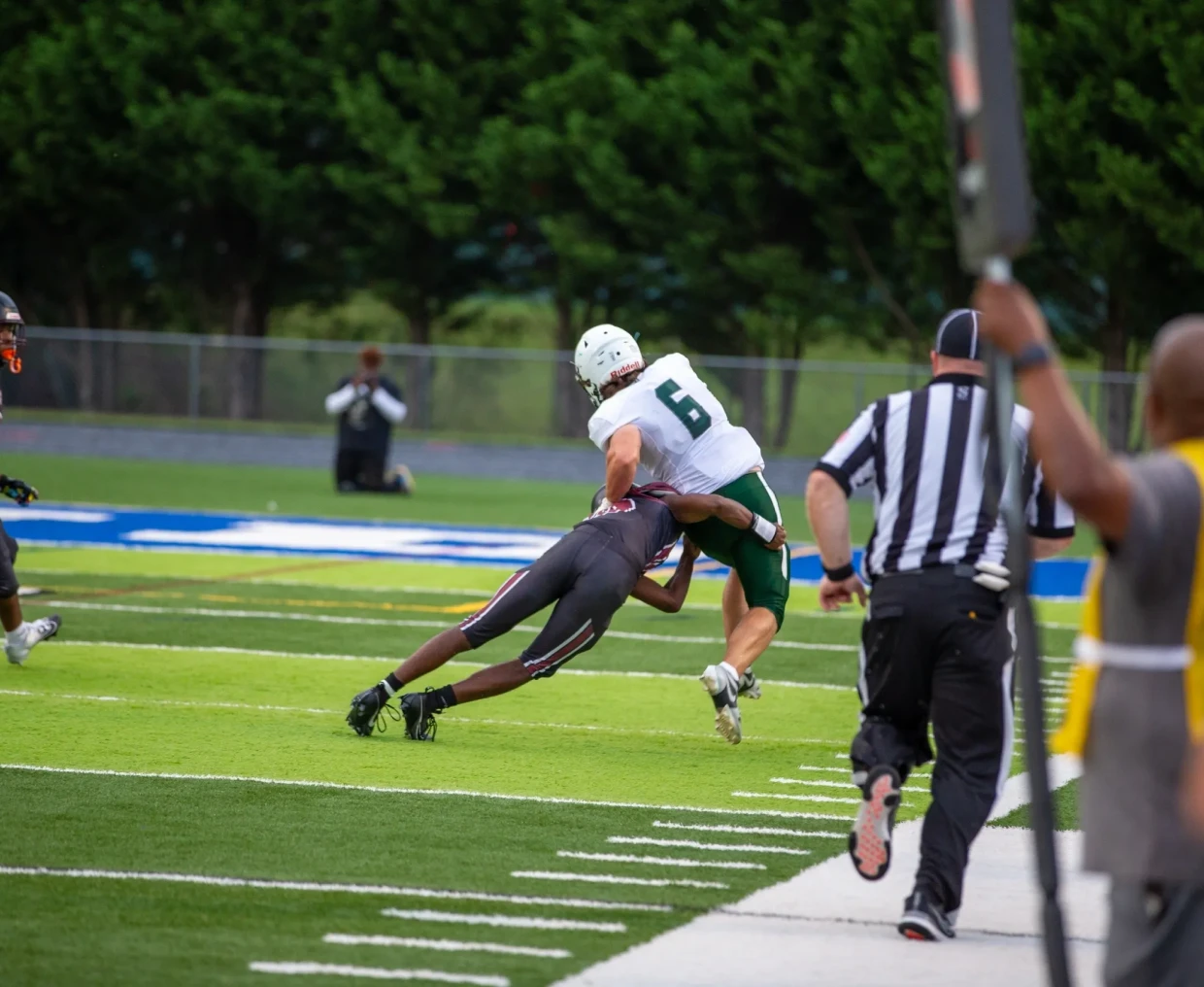 Football player tackling opponent on field.