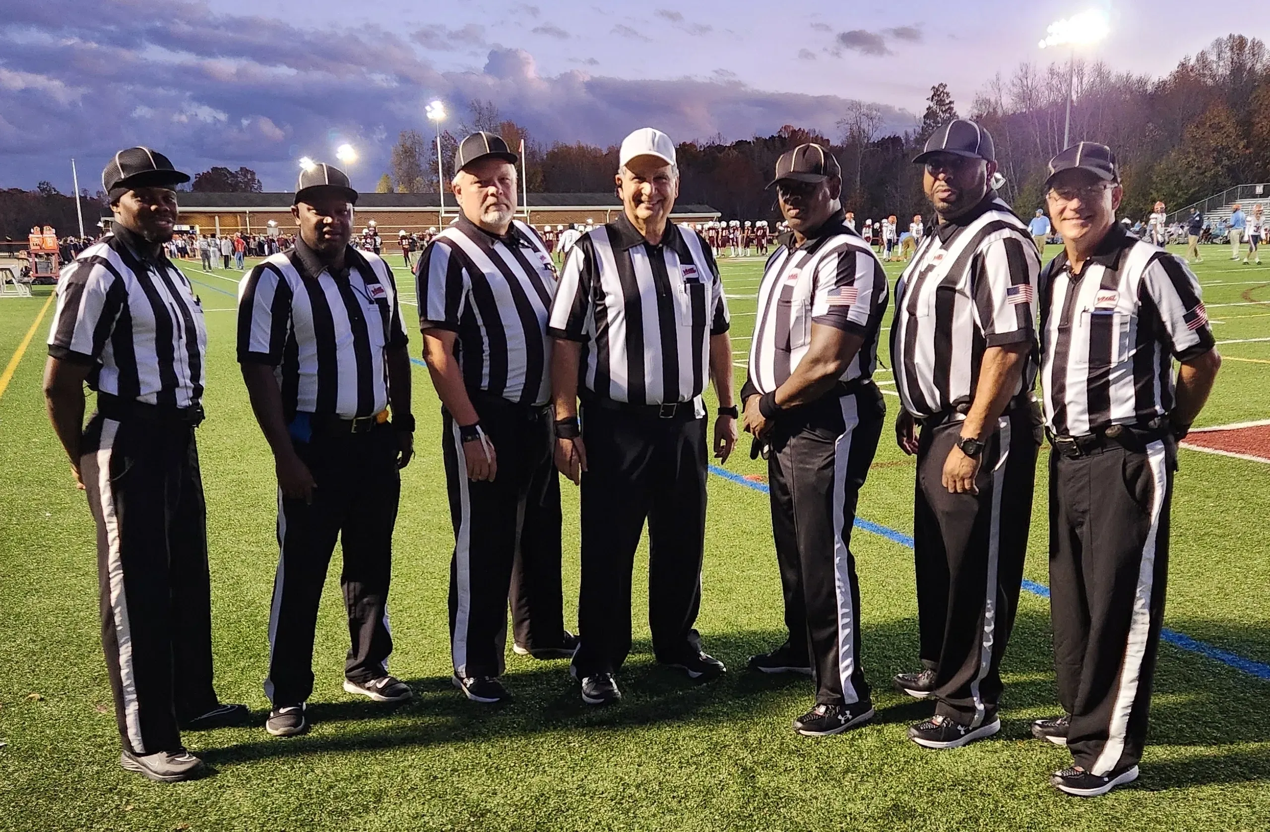 Football referees standing on a field together.