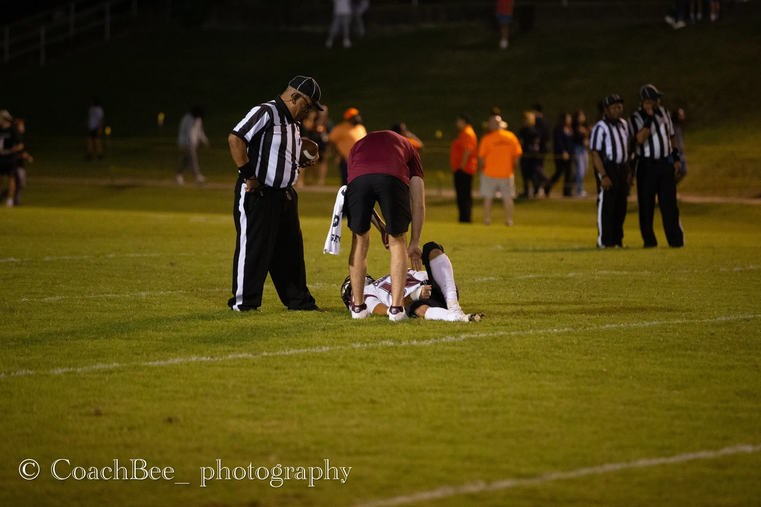 Injured football player attended by officials.