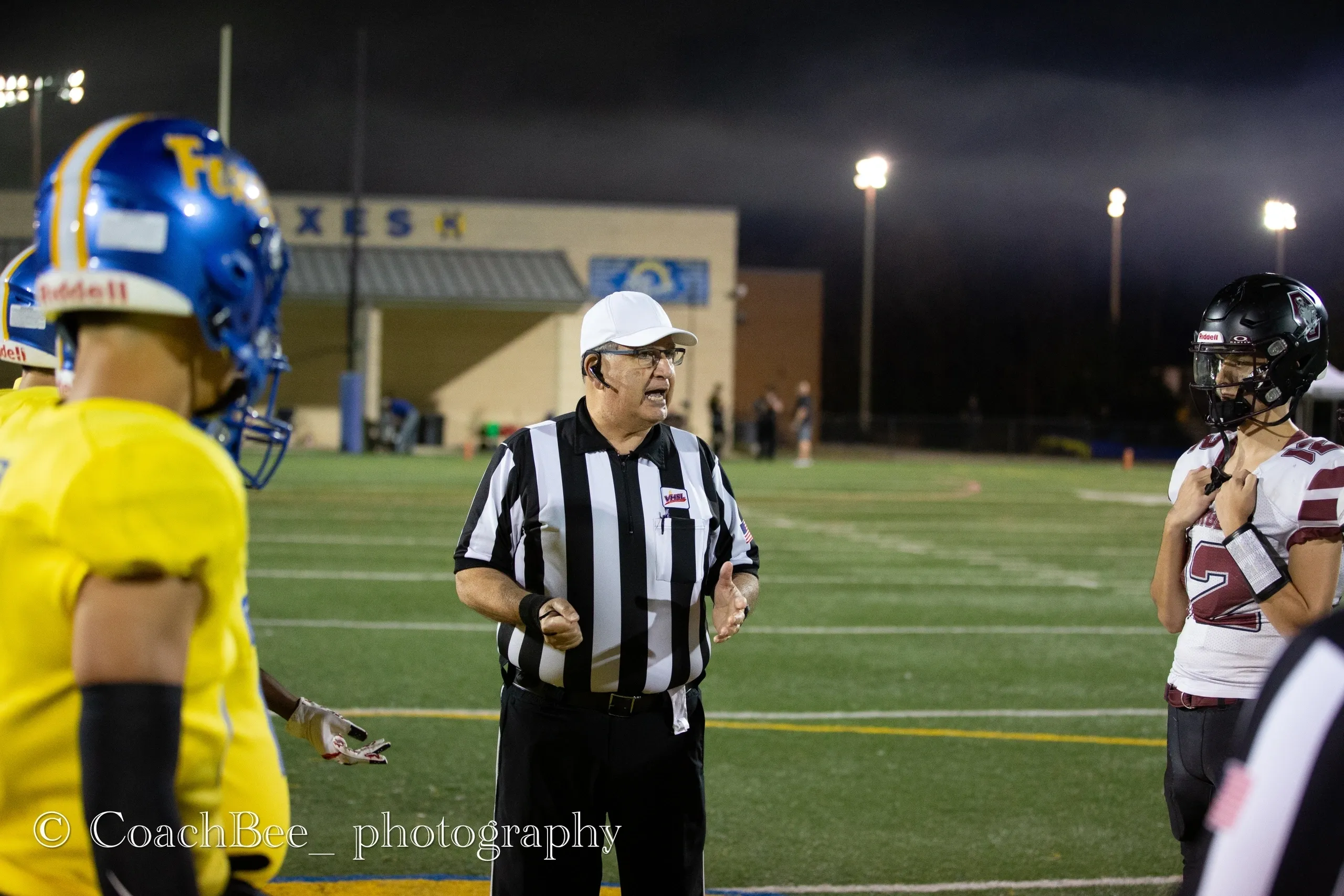 Referee and players during football coin toss.