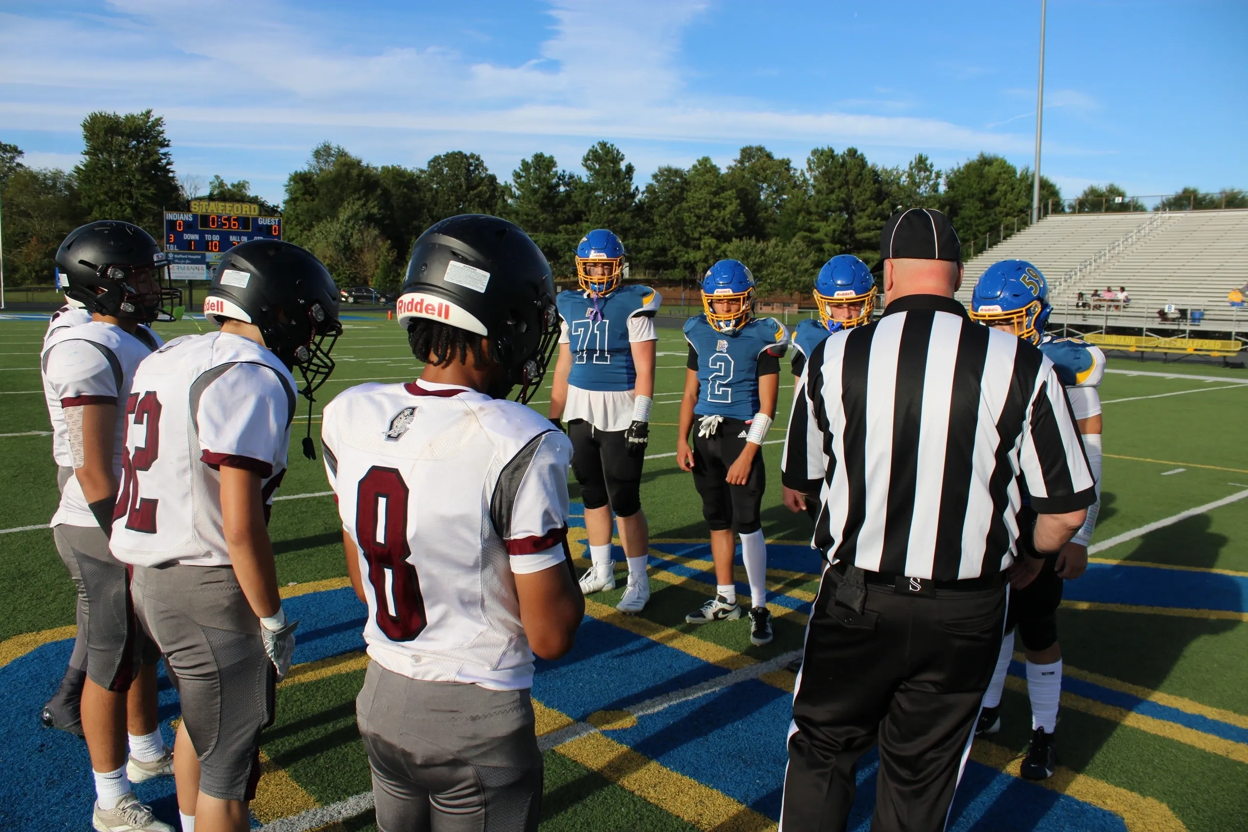 Football coin toss with referee and players.
