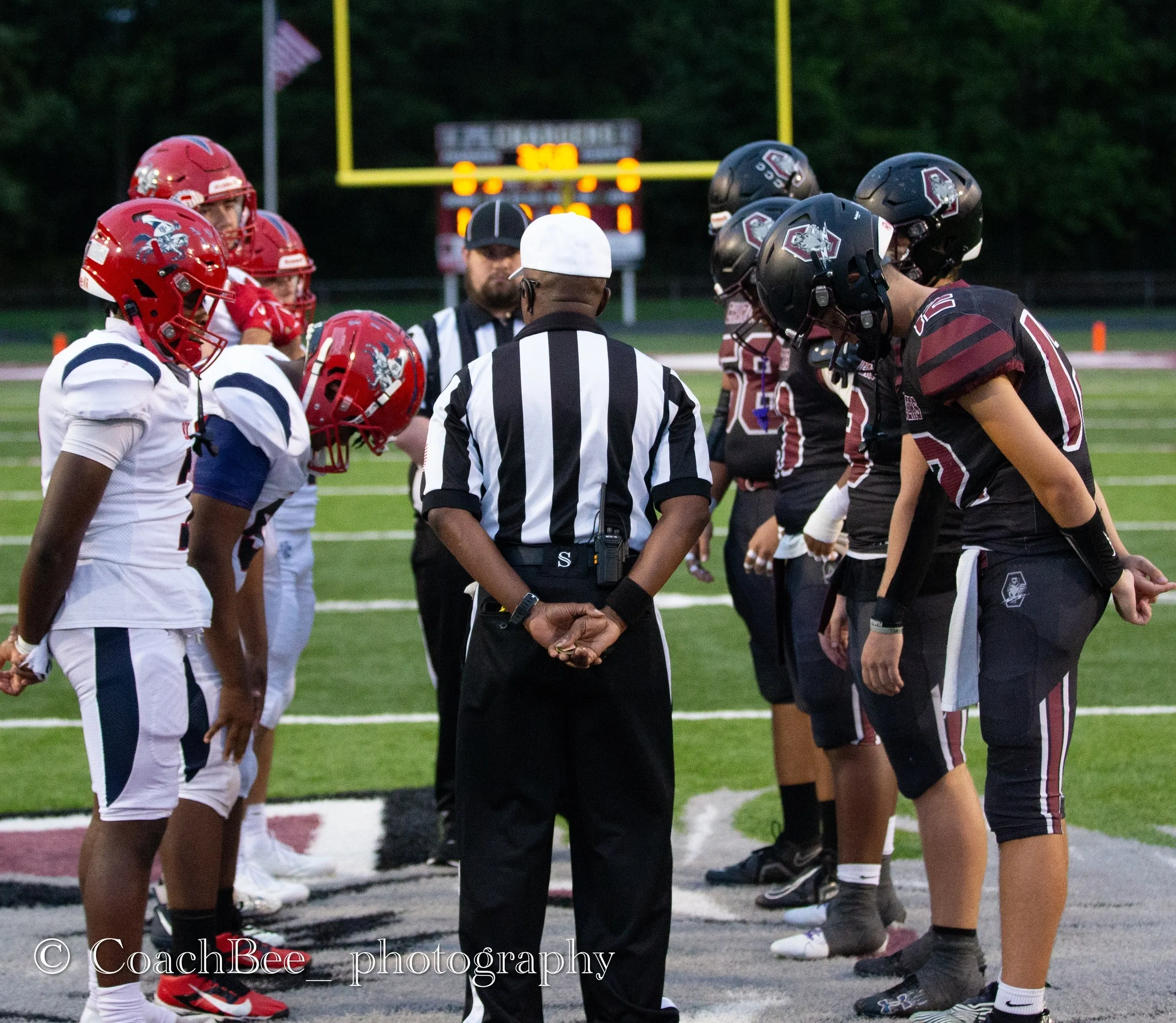 Football teams and referee during coin toss.